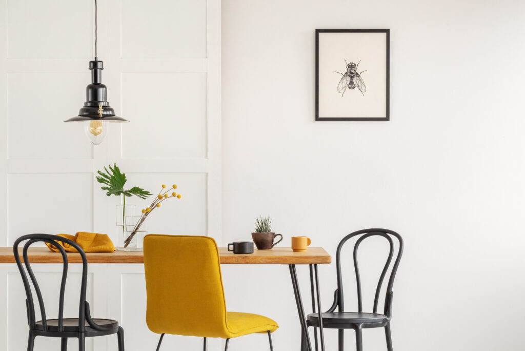 | Stylish yellow chair at wooden dining table in trendy interior