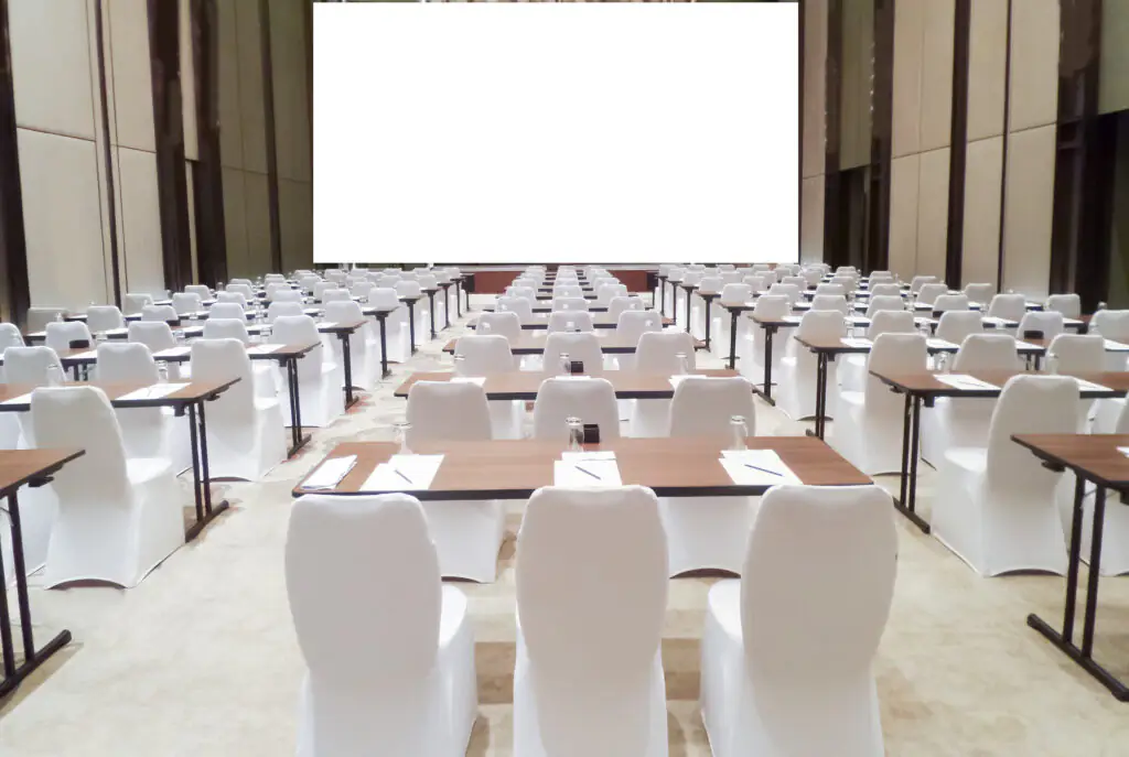 pokrowiec na krzesło bankietowe kolor biały pełny | bankietowo.pl | saminar meeting room with row of chair blank screen projector for adding message