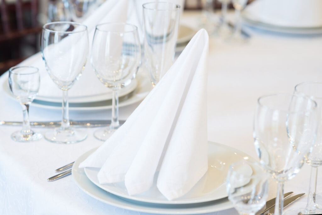 | Restaurant interior for banquet, wedding. Glass, napkins and cutlery. Table appointments, laying