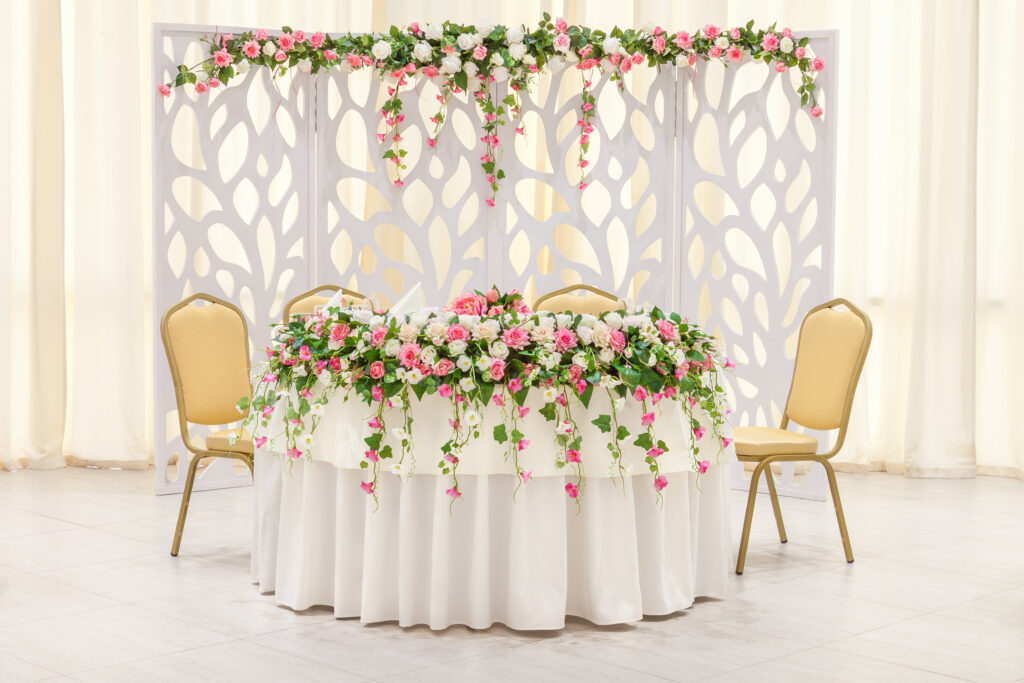 | The main table of the newlyweds, decorated with a floral composition and an arch in pastel colors