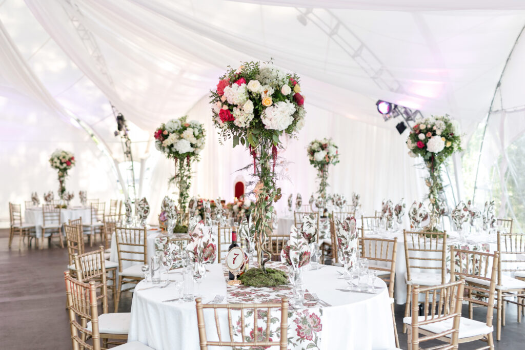 | Interior of a wedding tent decoration ready for guests. Served round banquet table outdoor in marquee decorated flowers and silk. Catering concept