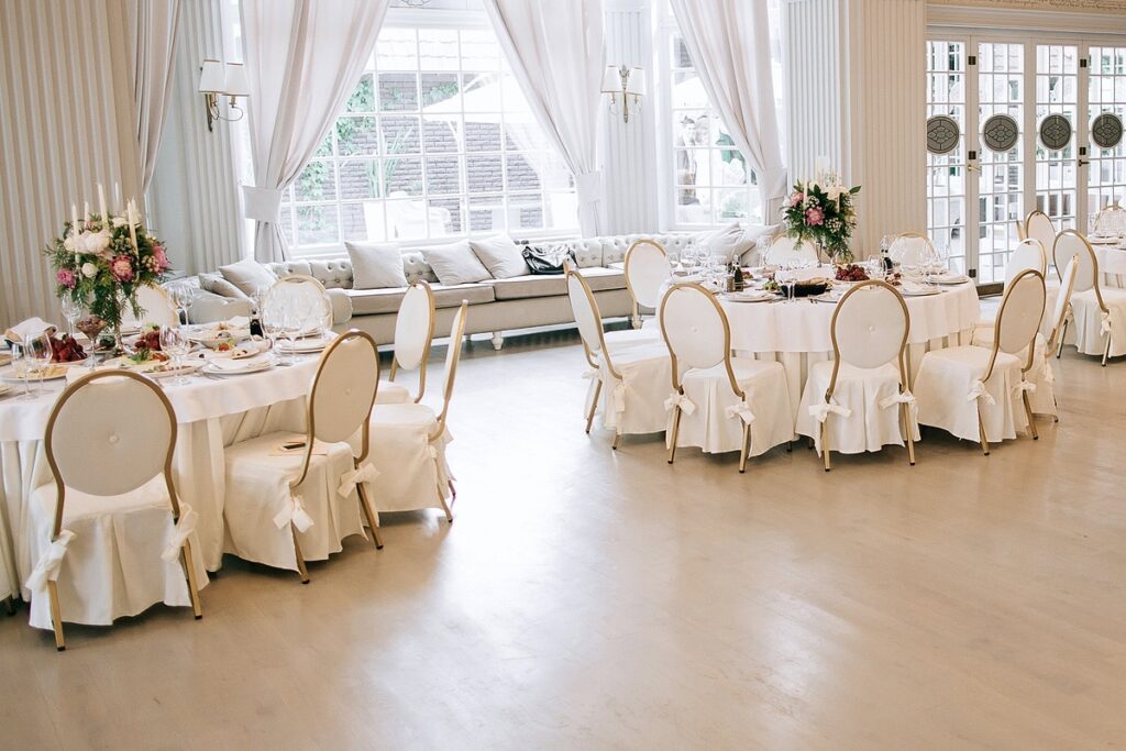 Sala weselna zaaranżowana z użyciem pięknych biało-złotych krzeseł